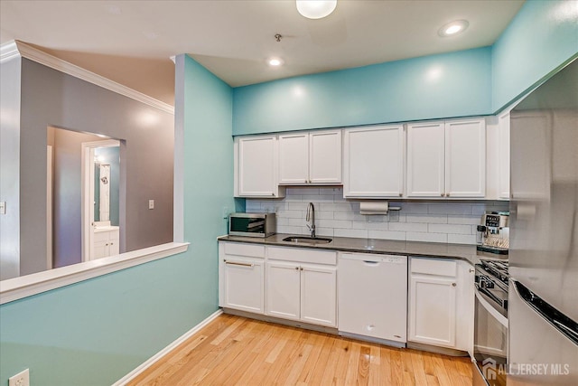 822 Dominick Ct, South Plainfield, NJ 07080 - kitchen with appliances with stainless steel finishes, a sink, backsplash, light wood-type flooring, and white cabinets
