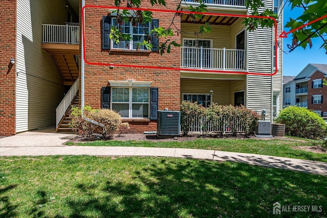 822 Dominick Ct, South Plainfield, NJ 07080 - view of front of property with brick siding, a balcony, central air condition unit, stairway, and a front lawn