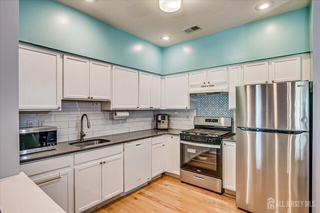 822 Dominick Ct, South Plainfield, NJ 07080 - kitchen with appliances with stainless steel finishes, a sink, under cabinet range hood, dark countertops, and recessed lighting