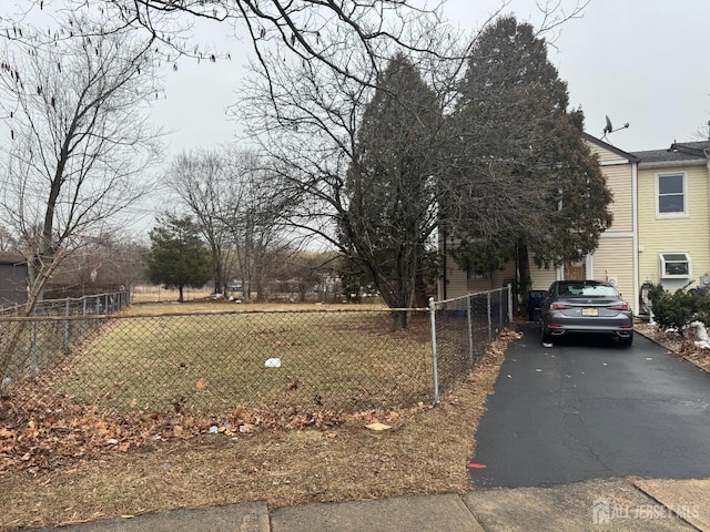 view of yard featuring driveway and fence