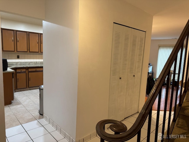 hall with stairway and light tile patterned flooring