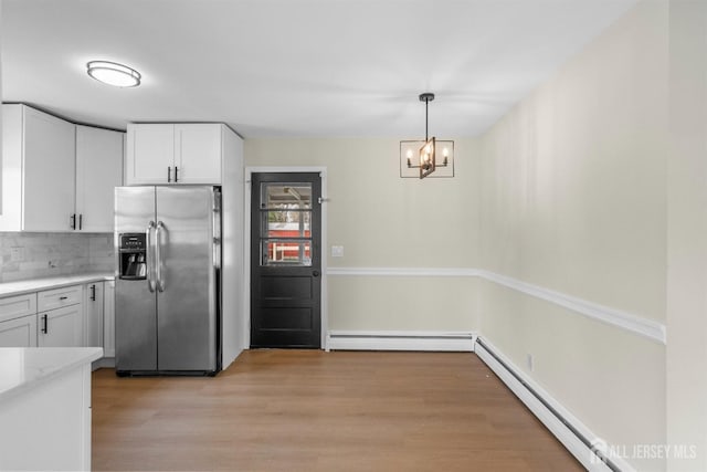 651 Myrtle Rd, North Brunswick, NJ 08902 - kitchen with stainless steel refrigerator with ice dispenser, baseboard heating, a baseboard heating unit, white cabinetry, and backsplash