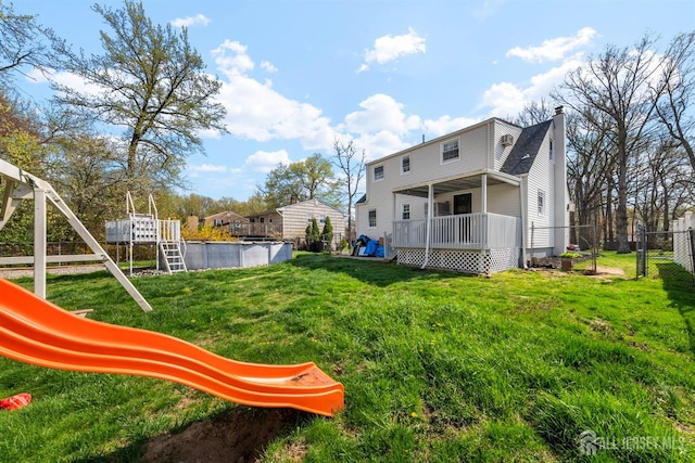 651 Myrtle Rd, North Brunswick, NJ 08902 - rear view of property with a chimney, an outdoor pool, and a wooden deck