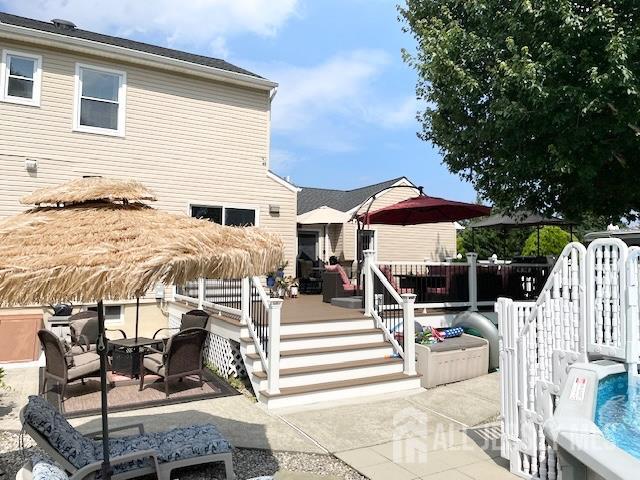 23 Prospect St, Old Bridge, NJ 08857 - back of property with a patio area and a wooden deck