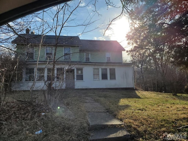 rear view of property with a lawn