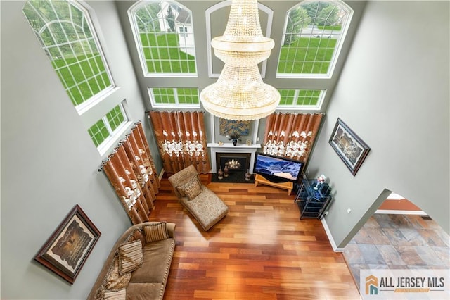 6 Monet Ct, South Brunswick, NJ 08852 - living area with a high ceiling, plenty of natural light, a lit fireplace, and wood finished floors