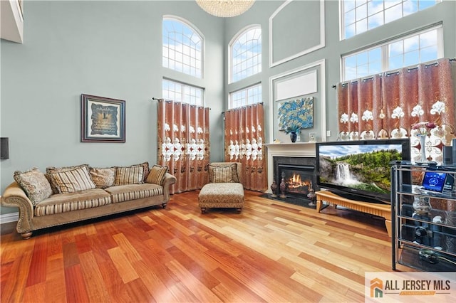 6 Monet Ct, South Brunswick, NJ 08852 - living room featuring wood finished floors, a towering ceiling, and a fireplace with flush hearth