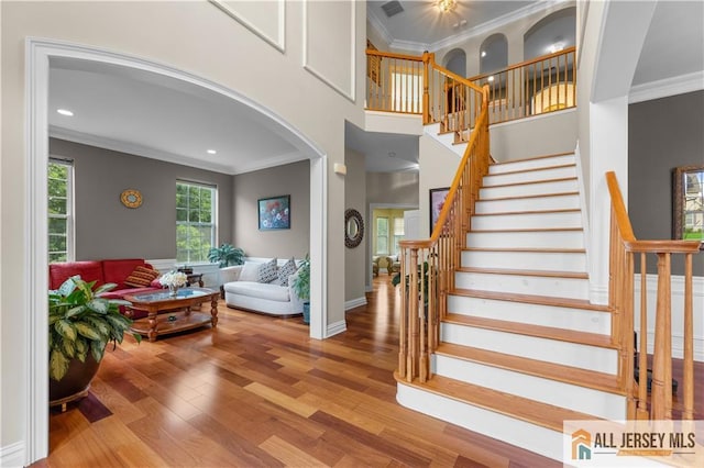6 Monet Ct, South Brunswick, NJ 08852 - stairway with ornamental molding, arched walkways, wood finished floors, and recessed lighting