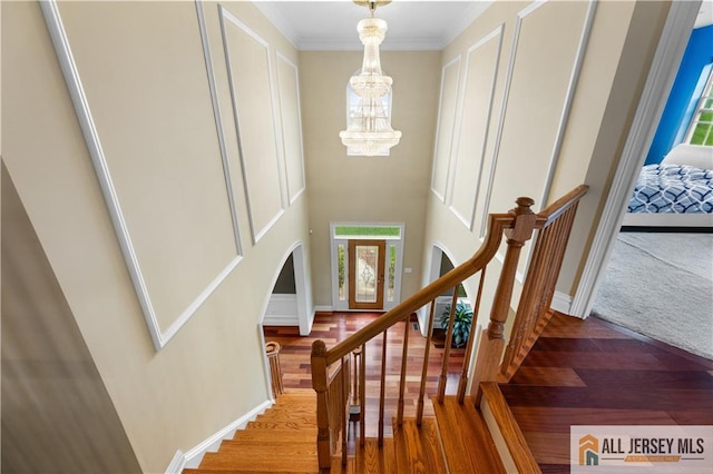 6 Monet Ct, South Brunswick, NJ 08852 - stairs featuring a chandelier, wood finished floors, arched walkways, and ornamental molding