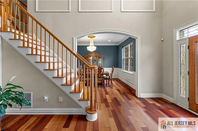 6 Monet Ct, South Brunswick, NJ 08852 - entrance foyer featuring plenty of natural light, arched walkways, wood finished floors, crown molding, and a towering ceiling