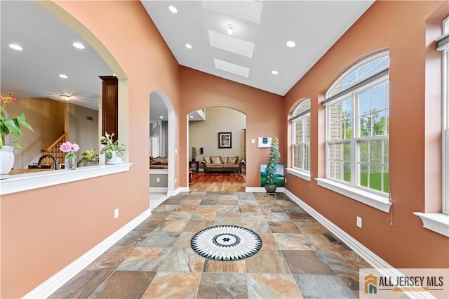 6 Monet Ct, South Brunswick, NJ 08852 - hall featuring plenty of natural light, stone finish floors, a skylight, recessed lighting, and arched walkways
