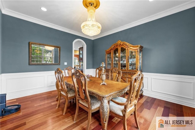 6 Monet Ct, South Brunswick, NJ 08852 - dining area with arched walkways, wood finished floors, a wainscoted wall, ornamental molding, and recessed lighting