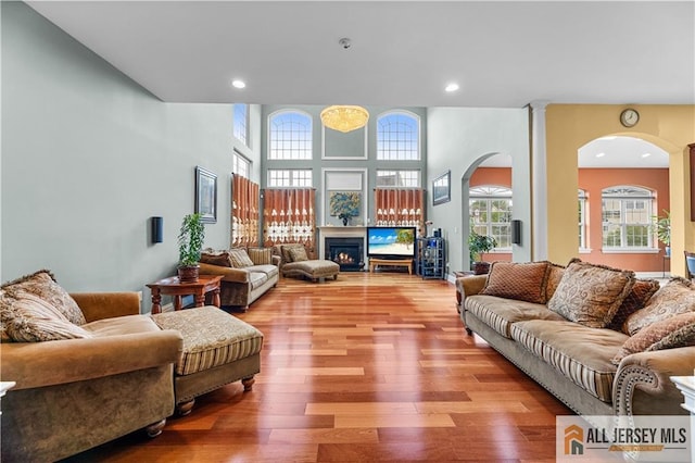 6 Monet Ct, South Brunswick, NJ 08852 - living area with arched walkways, wood finished floors, a glass covered fireplace, and recessed lighting