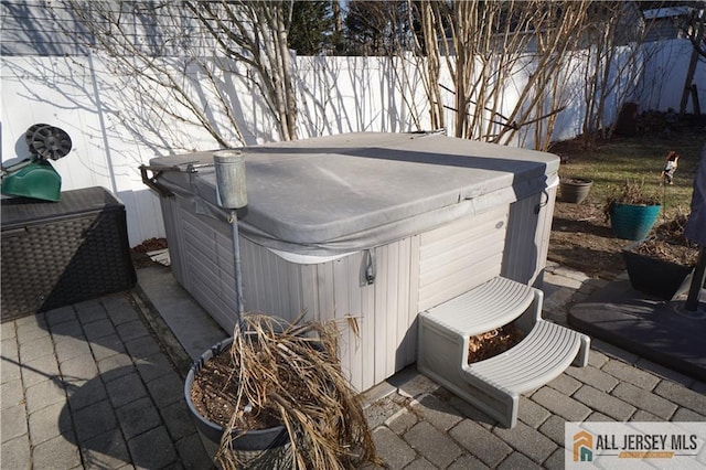 view of patio with fence and a hot tub