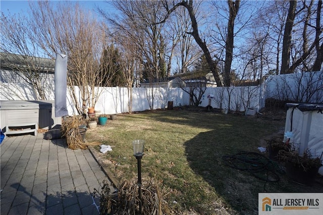 view of yard with a fenced backyard and a hot tub