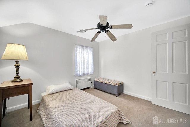 carpeted bedroom with a ceiling fan, baseboards, and radiator heating unit