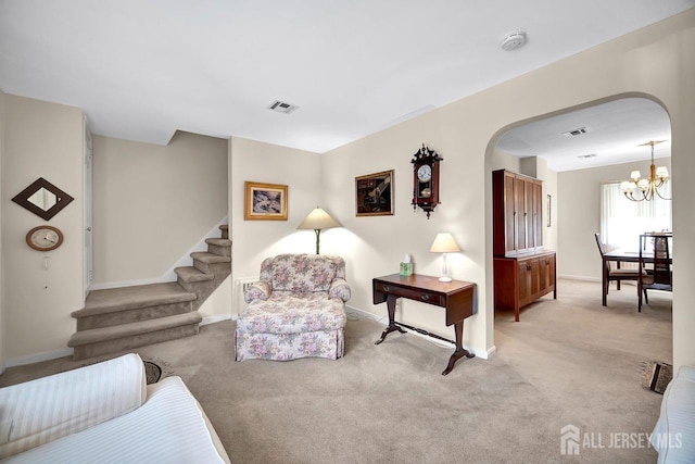 living area with carpet flooring, an inviting chandelier, arched walkways, visible vents, and stairway