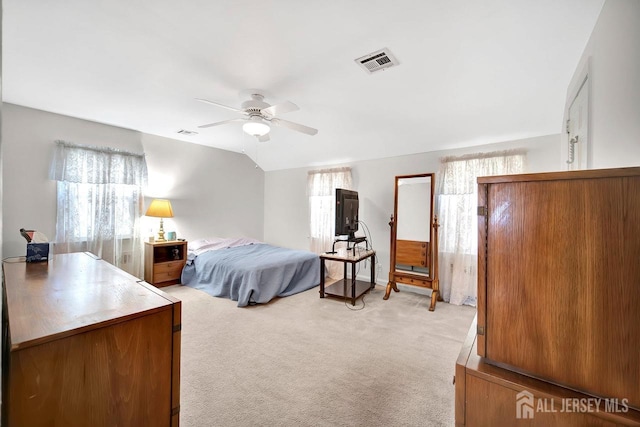 bedroom with visible vents, multiple windows, and light carpet