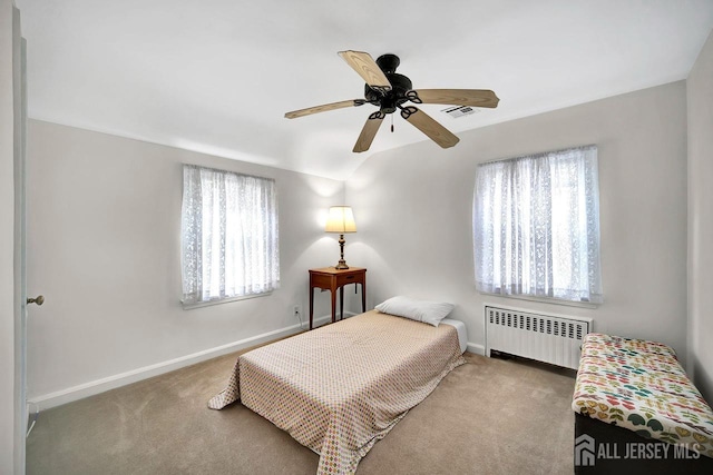 carpeted bedroom featuring baseboards, a ceiling fan, radiator heating unit, and visible vents