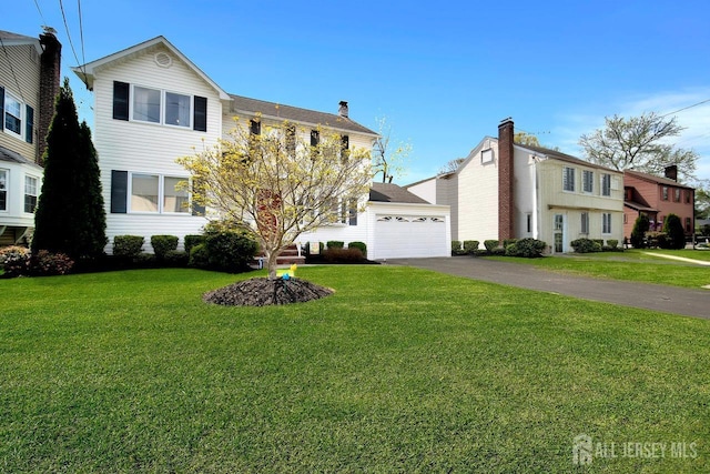 view of front of home featuring a garage, a front lawn, and driveway