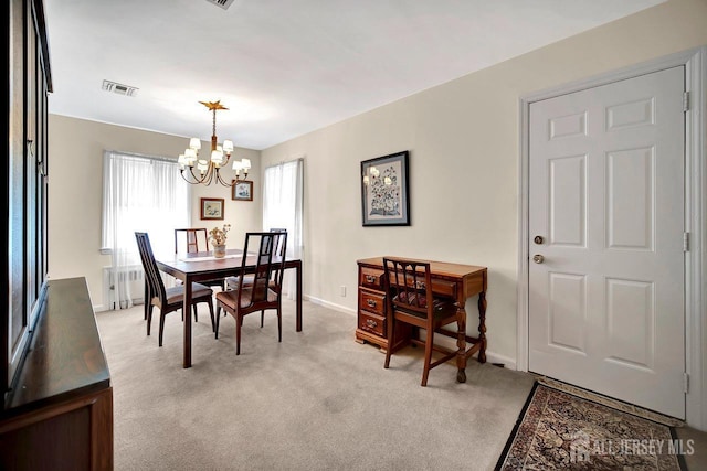 dining room with light colored carpet, a notable chandelier, visible vents, and baseboards