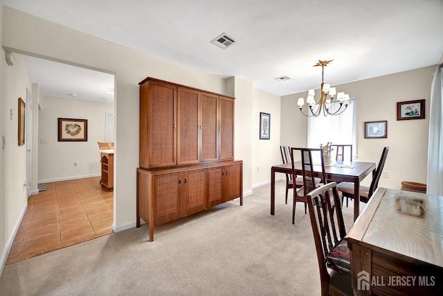 dining area with visible vents, light carpet, baseboards, a chandelier, and light tile patterned floors