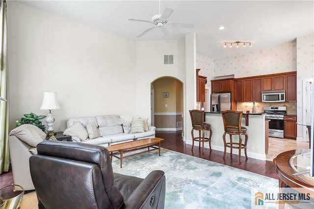 34 Schindler Ct Unit 17, Lawrence, NJ 08648 - living room featuring arched walkways, a ceiling fan, wallpapered walls, light wood finished floors, and baseboards