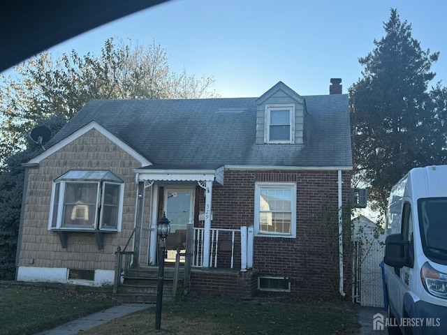 view of front facade featuring brick siding and a chimney