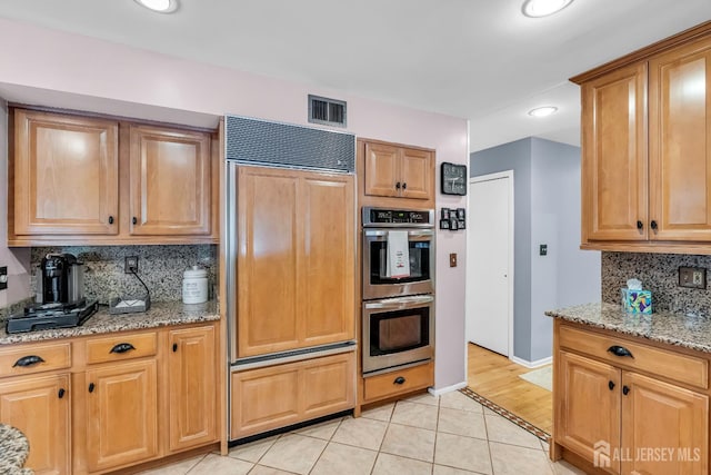 2 Crommelin Ct, East Brunswick, NJ 08816 - kitchen with paneled built in refrigerator, double oven, backsplash, light stone counters, and light tile patterned flooring