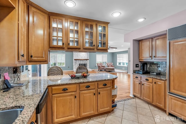 2 Crommelin Ct, East Brunswick, NJ 08816 - kitchen featuring a peninsula, dishwasher, decorative backsplash, light stone counters, and light tile patterned flooring