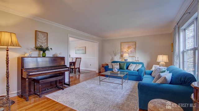 living area with ornamental molding, baseboards, and wood finished floors