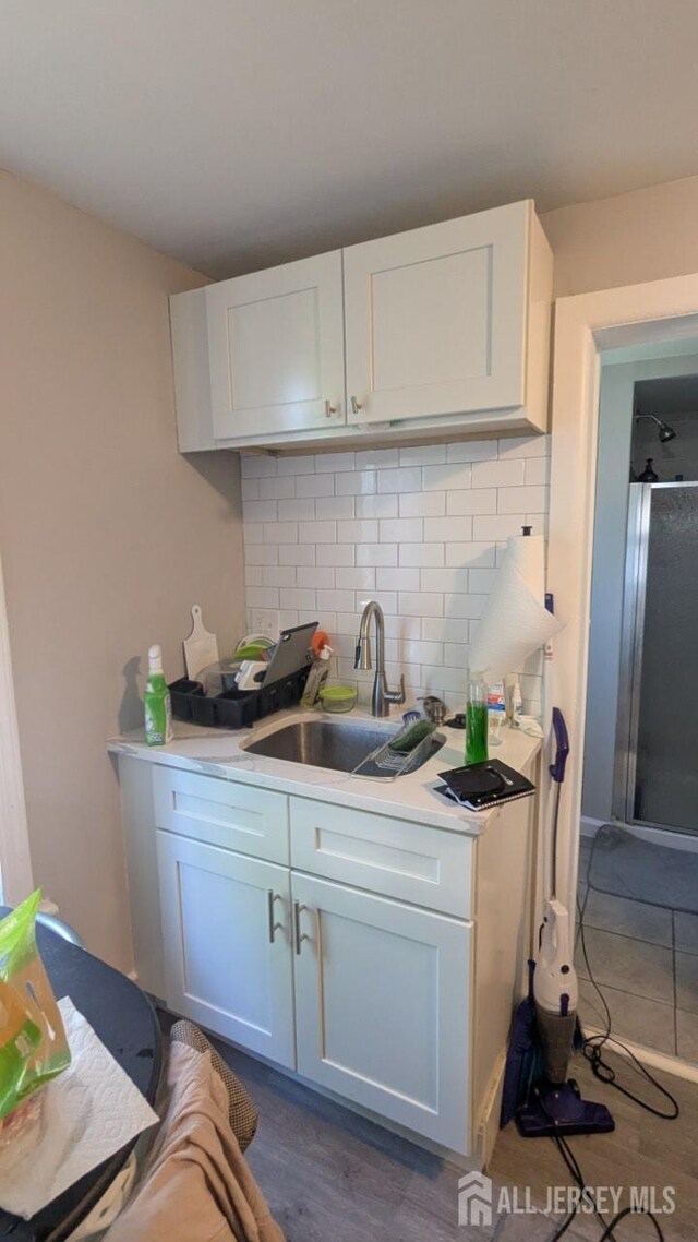 810-814 Leland Ave, Plainfield, NJ 07062 - kitchen featuring decorative backsplash, white cabinetry, light countertops, and dark wood-style flooring