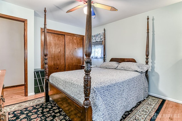 bedroom featuring a closet, a ceiling fan, baseboards, and wood finished floors