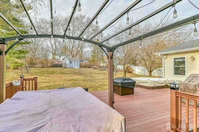 wooden terrace featuring an outdoor structure, a lawn, fence, and a pergola