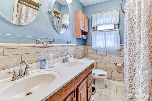 full bath featuring tile walls, toilet, double vanity, and a sink