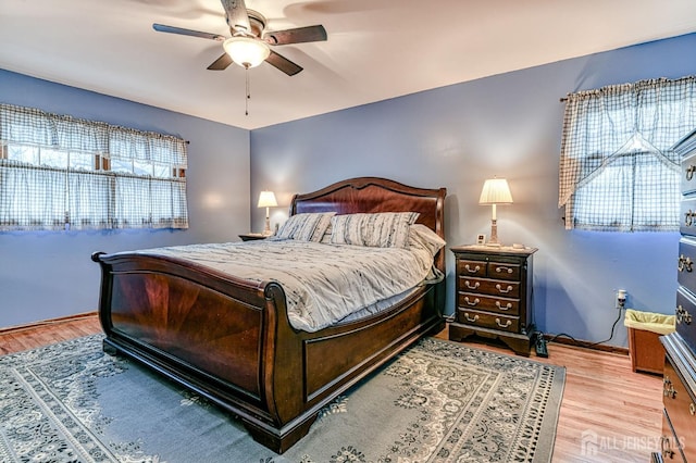 bedroom with baseboards, wood finished floors, and a ceiling fan