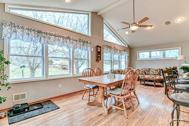 dining area with visible vents, baseboards, beamed ceiling, light wood-style flooring, and high vaulted ceiling