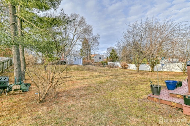 view of yard with an outdoor structure, a deck, and fence