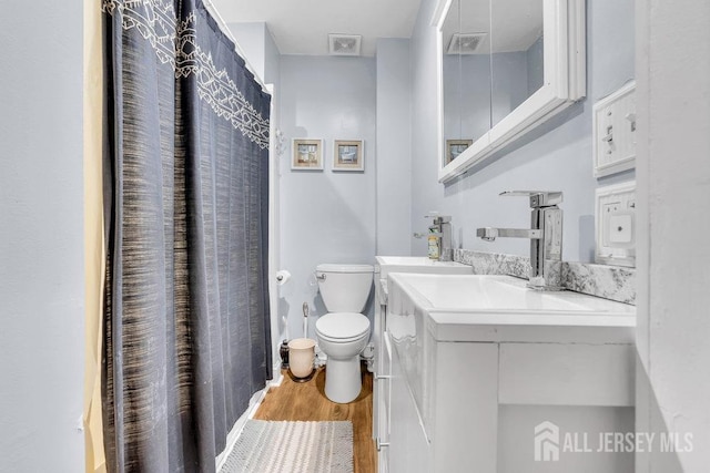 full bathroom with visible vents, toilet, wood finished floors, and vanity