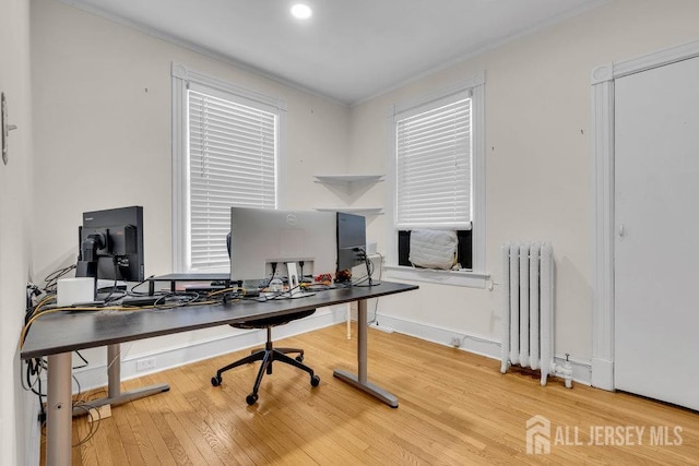 office space with baseboards, wood-type flooring, ornamental molding, and radiator heating unit