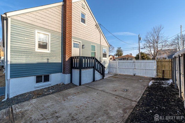 rear view of house featuring fence and a chimney