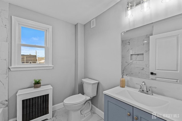 bathroom with vanity, tiled shower, radiator heating unit, and toilet