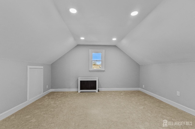 additional living space featuring lofted ceiling, heating unit, recessed lighting, baseboards, and light colored carpet