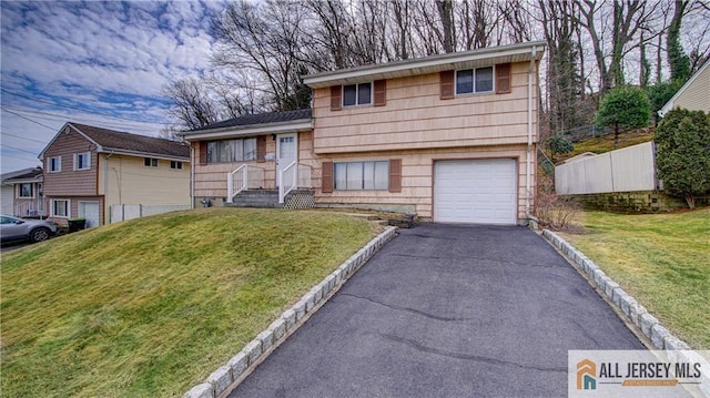 split level home featuring driveway, a front lawn, and an attached garage