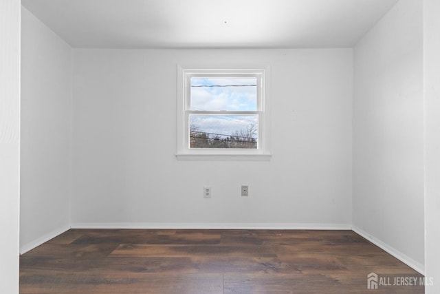 spare room featuring wood finished floors and baseboards