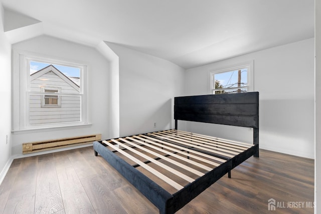 bedroom featuring lofted ceiling, a baseboard radiator, and wood finished floors