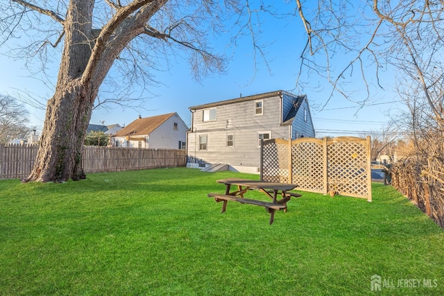 back of property featuring a fenced backyard and a yard