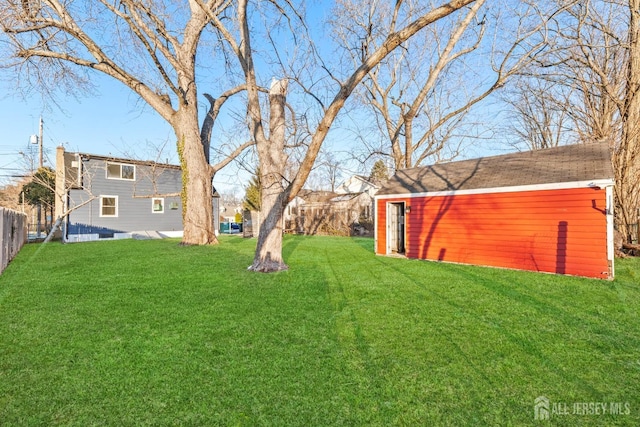 view of yard featuring an outdoor structure and fence