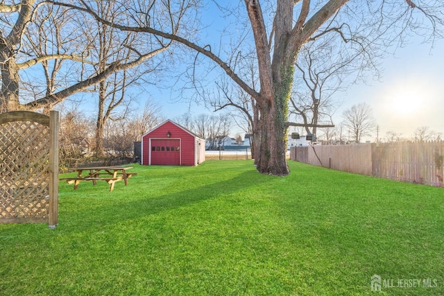 view of yard featuring a garage, an outdoor structure, and fence