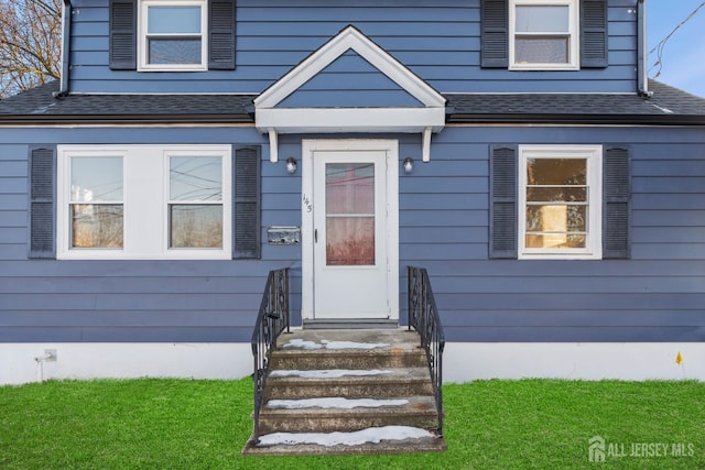 doorway to property with roof with shingles